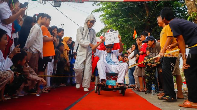 Peserta berpose saat mengikuti acara 'Ciliwung Fashion Week' di Kebon Baru, Jakarta Selatan, Rabu (17/8/2022). [Suara.com/Alfian Winanto]