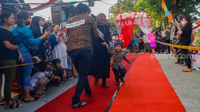 Peserta berpose saat mengikuti acara 'Ciliwung Fashion Week' di Kebon Baru, Jakarta Selatan, Rabu (17/8/2022). [Suara.com/Alfian Winanto]