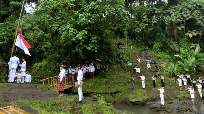 Warga mengikuti upacara bendera memperingati HUT ke-77 Kemerdekaan RI di Sungai Tukad Oos, Ubud, Gianyar, Bali, Rabu (17/8/2022).  ANTARA FOTO/Fikri Yusuf