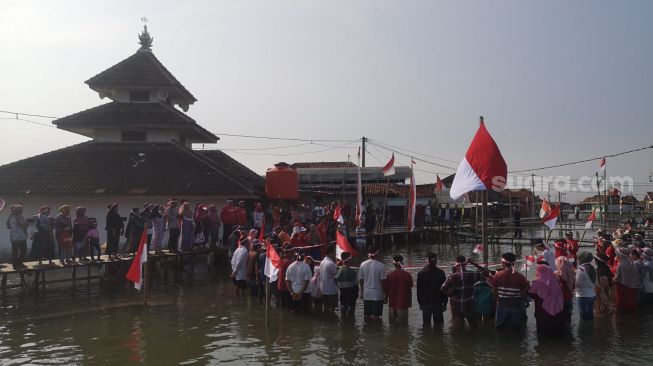 Bentuk Protes ke Pemerintah, Warga Demak Tetap Khidmat Gelar Upacara HUT ke-77 RI di Tengah Kepungan Banjir Rob