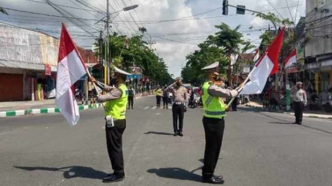 Pengendara motor di Jalan Kota Pamekasan diajak hormat bendera [Foto: Beritajatim]