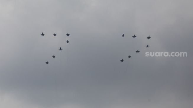 Pesawat Tempur F-16 TNI AU terbang membentuk formasi angka 77 di atas langit saat Peringatan Detik-Detik Proklamasi di Perpustakaan Nasional, Jakarta Pusat, Rabu (17/8/2022). [Suara.com/Alfian Winanto]