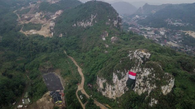 Foto udara pengibaran bendera Merah Putih raksasa saat upacara kemerdekaan di Geotheater Tebing Hawu, Padalarang, Kabupaten Bandung Barat, Jawa Barat, Rabu (17/8/2022). ANTARA FOTO/Raisan Al Farisi
