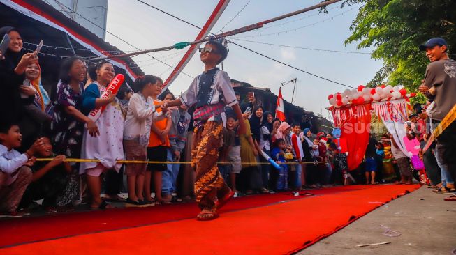 Peserta berpose saat mengikuti acara 'Ciliwung Fashion Week' di Kebon Baru, Jakarta Selatan, Rabu (17/8/2022). [Suara.com/Alfian Winanto]