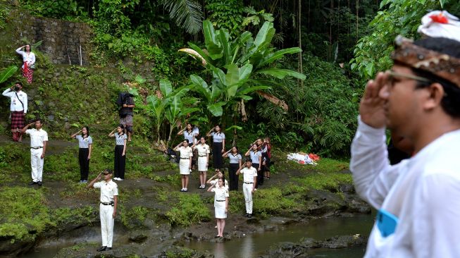 Warga mengikuti upacara bendera memperingati HUT ke-77 Kemerdekaan RI di Sungai Tukad Oos, Ubud, Gianyar, Bali, Rabu (17/8/2022).  ANTARA FOTO/Fikri Yusuf