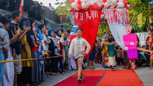 Peserta berpose saat mengikuti acara 'Ciliwung Fashion Week' di Kebon Baru, Jakarta Selatan, Rabu (17/8/2022). [Suara.com/Alfian Winanto]