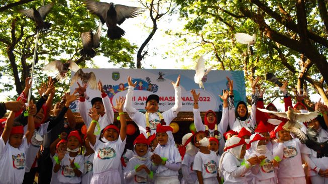 Wali Kota Madiun Maidi (tengah) bersama sejumlah anak Pendidikan Anak Usia Dini (PAUD) melepas burung merpati saat memperingati Hari Anak Nasional (HAN) 2022 di Kota Madiun, Jawa Timur, Jumat (19/8/2022). [ANTARA FOTO/Siswowidodo/wsj]