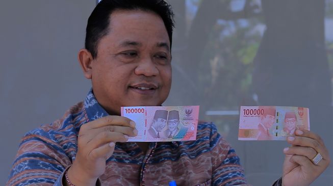 Kepala Bank Indonesia (BI) Perwakilan wilayah NTT I Nyoman Ariawan Atmaja menunjukkan uang kertas baru pecahan Rp100 ribu (kiri) dan pecahan Rp100 ribu lama saat peluncurannya di Kota Kupang, NTT, Kamis (18/8/2022). [ANTARA FOTO/Kornelis Kaha/rwa]