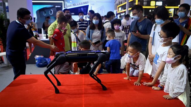 Orang-orang melihat robot berkaki empat pada acara Konferensi Robot Dunia 2022 di Beijing, China, Kamis (18/8/2022). [WANG Zhao/AFP]