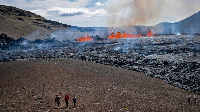 Sejumlah orang mengunjungi lokasi erupsi Gunung Fagradalsfjall di Grindavik, Islandia, Kamis (4/8/2022). [Jeremie RICHARD / AFP]