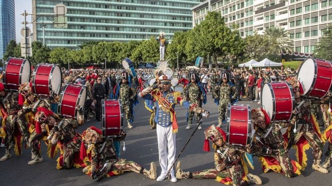 Sejumlah Taruna Akademi TNI Akmil, AAU dan AAL melakukan atraksi saat kirab drumband Akademi TNI di kawasan Bundaran HI, Jakarta, Minggu (21/8/2022).  ANTARA FOTO/Muhammad Adimaja
