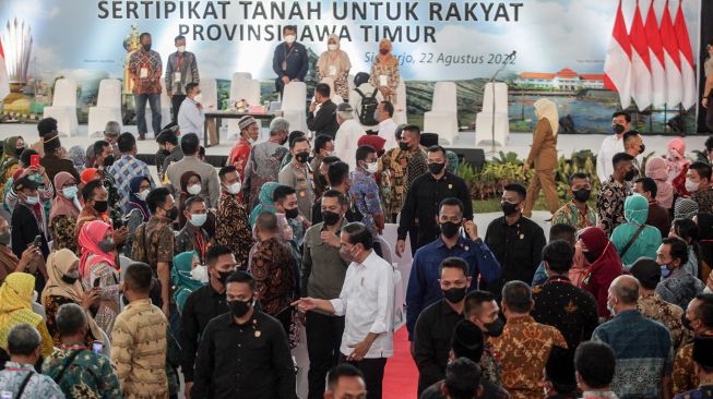 Presiden Joko Widodo mengangkat sertifikat tanah warga saat penyerahan sertipikat tanah untuk rakyat Jawa Timur di Gelora Delta Sidoarjo, Jawa Timur, Senin (22/8/2022). ANTARA FOTO/Umarul Faruq
