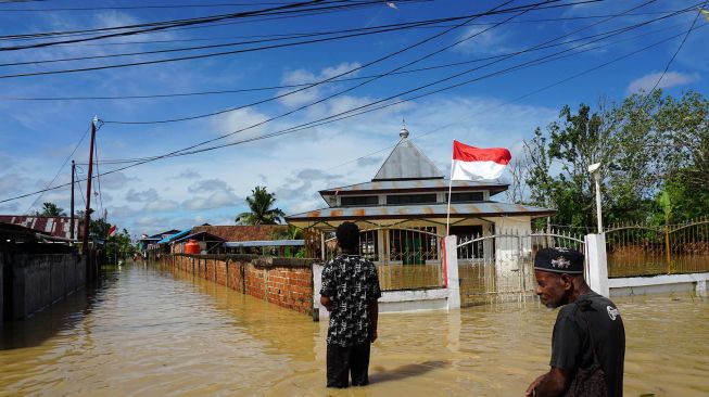 Warga berjalan menerobos banjir di kompleks Kokoda Kota Sorong, Papua Barat, Selasa (23/8/2022). ANTARA FOTO/Olha Mulalinda
