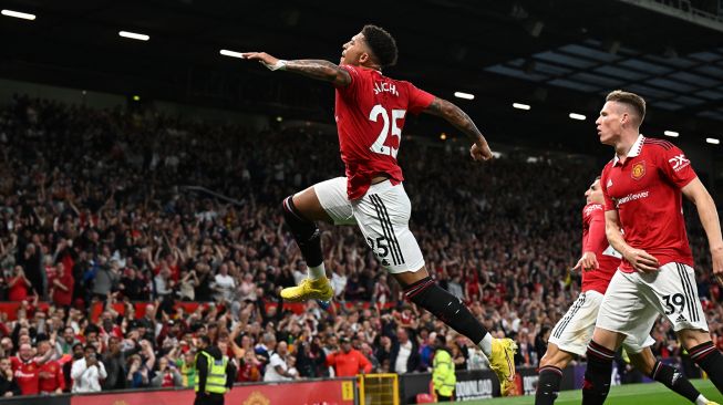 Striker Manchester United Jadon Sancho (tengah) merayakan golnya setelah mencetak gol pembuka selama pertandingan sepak bola Liga Premier Inggris antara Manchester United melawan Liverpool di Old Trafford, Selasa (23/8/2022) dini hari WIB. Paul ELLIS / AFP
