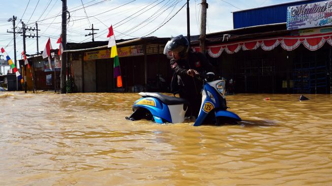 Pengendara sepeda motor menerobos banjir di Jalan Basuki Rahmat Kota Sorong, Papua Barat, Selasa (23/8/2022).  ANTARA FOTO/Olha Mulalinda