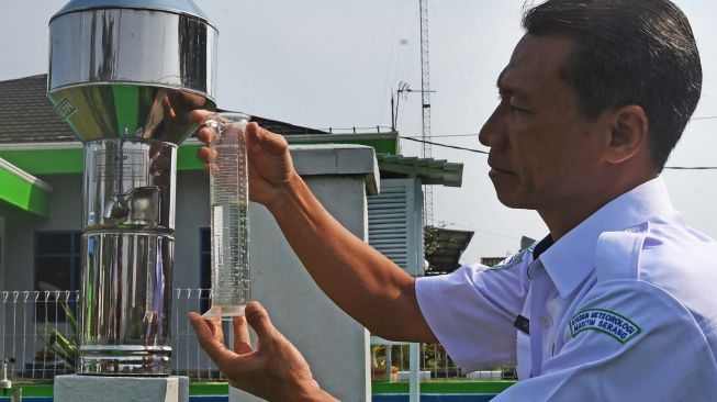 Petugas Badan Meteorologi Klimatologi dan Geofisika (BMKG) Banten mengukur volume air hujan yang ditampung alat pengukur curah hujan (Rainfall Hellman) di Serang, Banten, Selasa (23/10/2022). ANTARA FOTO/Asep Fathulrahman

