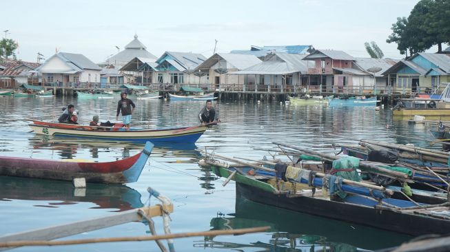 Warga menaiki perahu di sekitar rumah warga Suku Bajau di Desa Bajo, Tilamuta, Kabupaten Boalemo, Gorontalo, Rabu (24/8/2022).  ANTARA FOTO/Adiwinata Solihin
