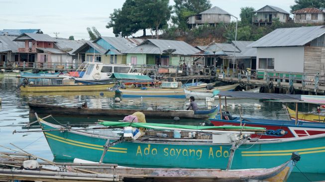 Warga menaiki perahu di sekitar rumah warga Suku Bajau di Desa Bajo, Tilamuta, Kabupaten Boalemo, Gorontalo, Rabu (24/8/2022).  ANTARA FOTO/Adiwinata Solihin
