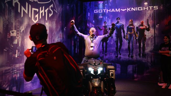 Pengunjung berswafoto di stan game 'Gotham Knights' dsaat pameran video game Gamescom di Cologne, Jerman, Rabu (24/8/2022). [Ina FASSBENDER / AFP]
