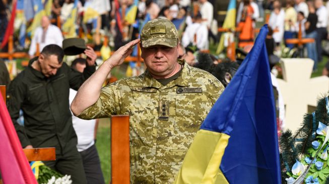 Seorang tentara Ukraina memberi hormat saat menghadiri upacara untuk tentara Ukraina yang gugur di Pemakaman Lychakiv, Lviv, Ukraina, Rabu (24/8/2022). [YURIY DYACHYSHYN / AFP]