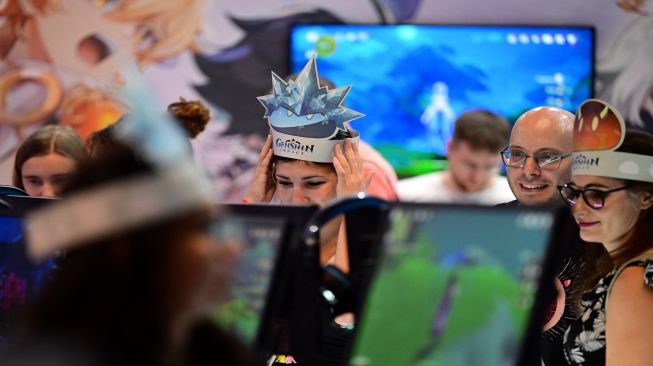 Pengunjung memainkan game 'Genshin Impact', sebuah game role-playing aksi fantasi oleh pengembang Cina miHoYo saat pameran video game Gamescom di Cologne, Jerman, Rabu (24/8/2022). [Ina FASSBENDER / AFP]