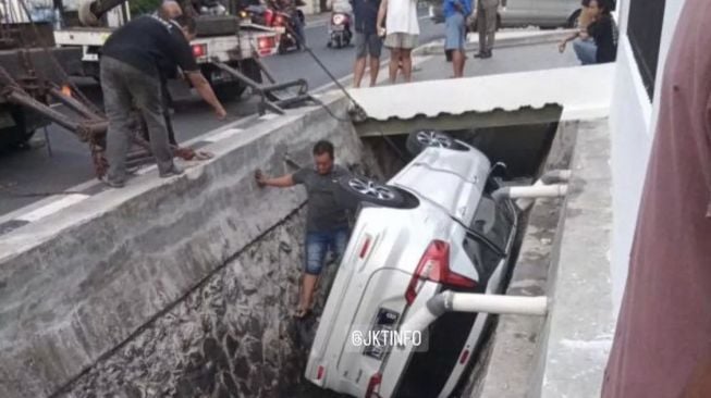 Mobil Suzuki Ertiga Terperosok ke Saluran Air di Jalan Dharmawangsa X Jaksel, Polisi: Pengendara Tak Dalam Keadaan Mabuk