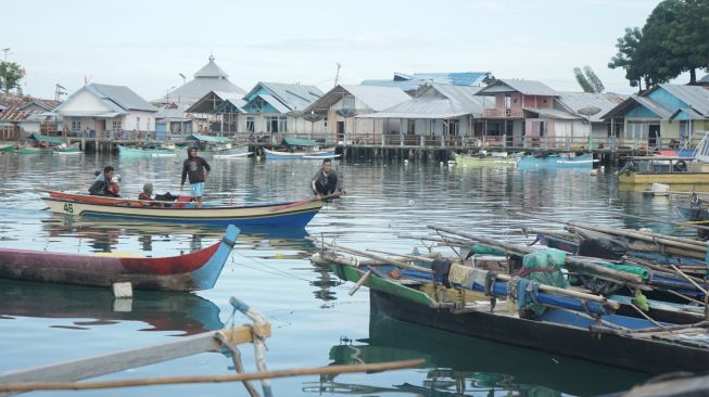 Warga menaiki perahu di sekitar rumah warga Suku Bajau di Desa Bajo, Tilamuta, Kabupaten Boalemo, Gorontalo, Rabu (24/8/2022). [ANTARA FOTO/Adiwinata Solihin/aww]