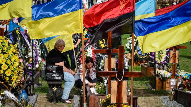 Warga memberi penghormatan selama upacara untuk tentara Ukraina yang gugur ddi Pemakaman Lychakiv, Lviv, Ukraina, Rabu (24/8/2022). [YURIY DYACHYSHYN / AFP]
