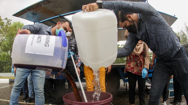 Sejumlah petugas BNNP Kepri menuangkan sabu cair ke dalam wadah berisi air saat dimusnahkan dengan cara dilarutkan di halaman Kantor BNNP Kepri, Batam, Kepulauan Riau, Kamis (25/8/2022). 
[ANTARA FOTO/Teguh Prihatna/wsj]