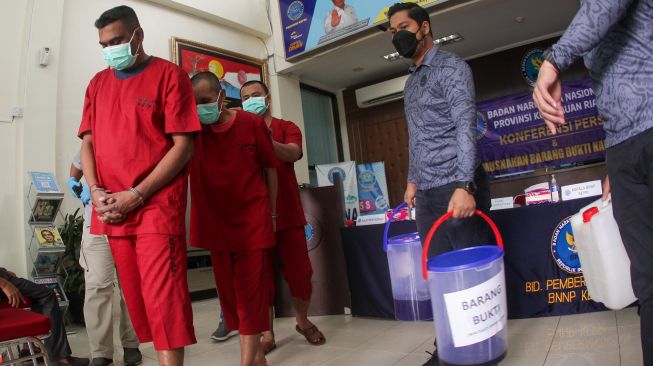 Tiga tersangka pemilik dan pekerja industri rumahan narkotika jenis sabu dihadirkan saat pemusnahan di halaman Kantor BNNP Kepri, Batam, Kepulauan Riau, Kamis (25/8/2022). [ANTARA FOTO/Teguh Prihatna/wsj]