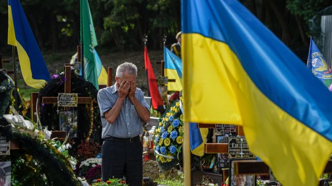 Seorang pria tua berkabung saat upacara untuk tentara Ukraina yang gugur di Pemakaman Lychakiv, Lviv, Ukraina, Rabu (24/8/2022). [YURIY DYACHYSHYN / AFP]