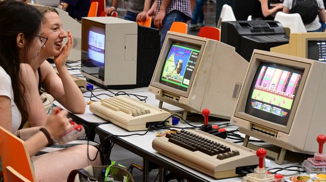 Pengunjung bermain game Retro klasik saat pameran video game Gamescom di Cologne, Jerman, Rabu (24/8/2022). [Ina FASSBENDER / AFP]