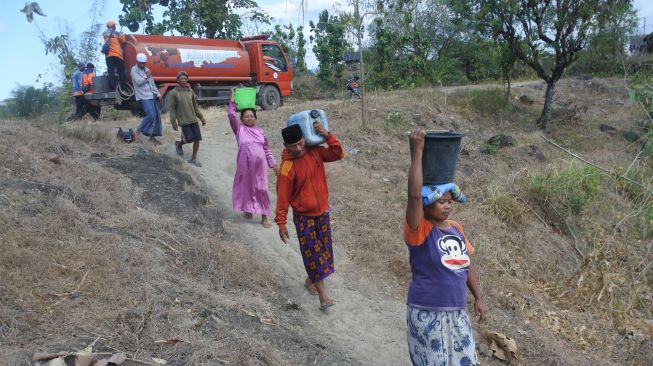 Sejumlah warga membawa air bersih yang didistribusikan di Desa Jatisari, Arjasa, Situbondo, Jawa Timur, Kamis (25/8/2022). [ANTARA FOTO/Seno/hp]