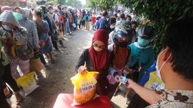 Warga antre membeli beras murah saat operasi pasar di Kota Kediri, Jawa Timur, Jumat (26/8/2022). [ANTARA FOTO/Prasetia Fauzani/foc]