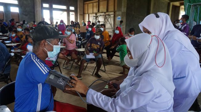 Petugas medis memeriksa tekanan darah seorang warga pada kegiatan pengobatan massal gratis di Kampus STIKES Papua, Kota Sorong, Papua Barat, Sabtu (27/8/2022). [ANTARA FOTO/Olha Mulalinda/tom]
