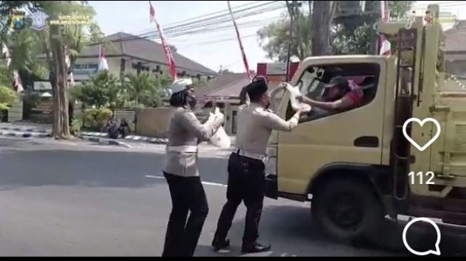 Dalam razia Jumat Berkah Polres Jombang, kendaraan yang melintas lokasi razia dibagi masker dan nasi bungkus [Instagram: polresjombang].
