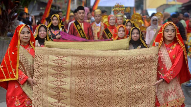 Peserta membawa kain songket saat mengikuti parade 1.000 songket, pada Festival Pandai Sikek, di Nagari Pandai Sikek, Kabupaten Tanah Datar, Sumatera Barat, Sabtu (27/8/2022). [ANTARA FOTO/Iggoy el Fitra/tom]
