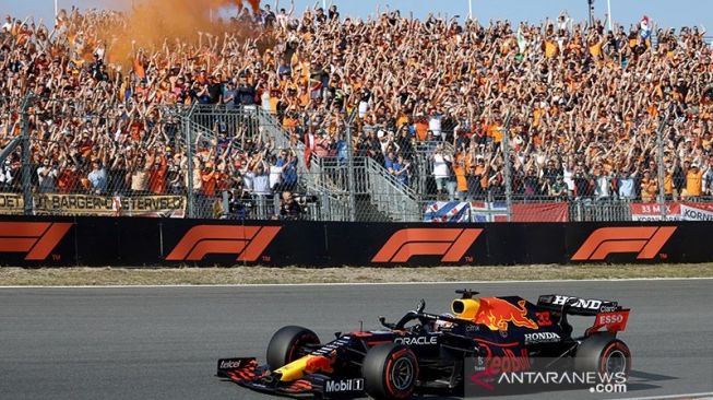 Pendukung Orange Army bergembira saat pebalap F1 Red Bull, Max Verstappen melakukan lintatasan selebrai usai menjuarai balapan di sirkuit Zandvoort, Belanda (5/9/2021). ANTARA/AFP/Kenzo Tribouillard/aa.