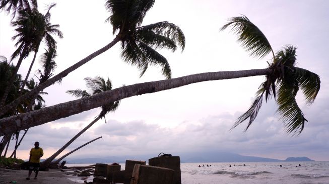 Pengunjung berjalan di bibir Pantai Holtekamp, Distrik Muara Tami, Kota Jayapura, Papua, Jumat (26/8/2022). [ANTARA FOTO/Sakti Karuru/wsj]
