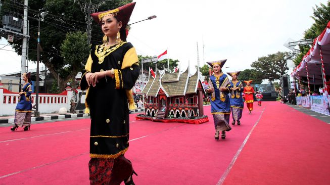 Peserta mengenakan pakaian adat Minangkabau melintas di area Blitar Ethnic National (BEN) Carnival 2022 di Kota Blitar, Jawa Timur, Sabtu (27/8/2022). [ANTARA FOTO/Irfan Anshori/tom]