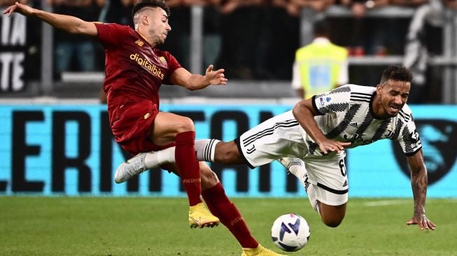 Pemain depan AS Roma Stephan El Shaarawy (kiri) menjegal bek Juventus Danilo selama pertandingan sepak bola Serie A Italia antara Juventus melawan AS Roma  di Stadion Allianz, Minggu (28/8/2022) dini hari WIB. Marco BERTORELLO / AFP

