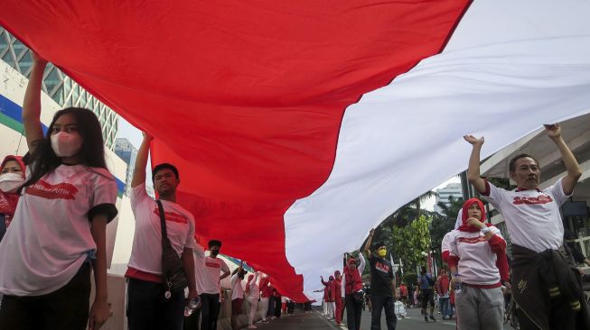 Peserta membentangkan Bendera Merah Putih di kawasan Thamrin, Jakarta, Minggu (28/8/2022). ANTARA FOTO/M Risyal Hidayat