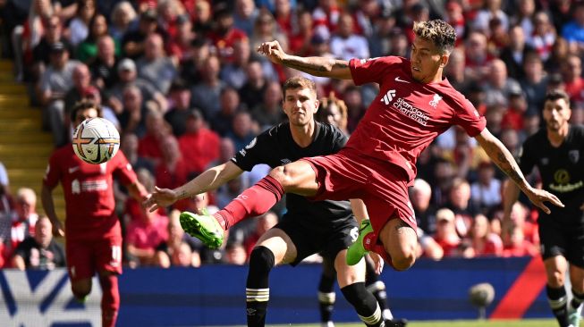 Striker Liverpool Roberto Firmino (tengah) menembak untuk mencetak gol keempat mereka selama pertandingan sepak bola Liga Premier Inggris antara Liverpool melawan Bournemouth di Anfield, Sabtu (27/8/2022) malam WIB, Oli SCARFF / AFP
