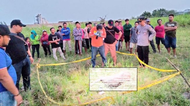 Polisi melakukan olah TKP di lokasi penemuan mayat wanita telanjang di persawahan Desa/Kecamatan Bandarkedungmulyo, Kabupaten Jombang, Sabtu (27/8/2022).[SuaraJatim/Zen Arivin].