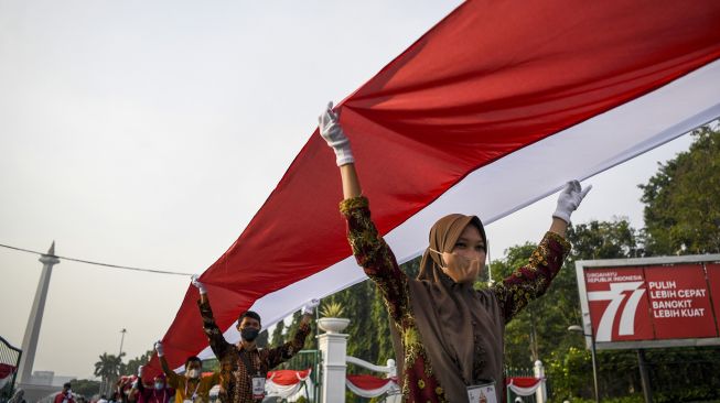 Peserta membentangkan Bendera Merah Putih di kawasan Thamrin, Jakarta, Minggu (28/8/2022). ANTARA FOTO/M Risyal Hidayat