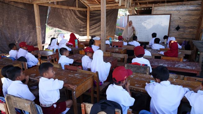 Siswa belajar di tenda darurat SD Inpres Binanga 2 Mamuju, Sulawesi Barat, Senin (29/8/2022).  ANTARA FOTO/Akbar Tado