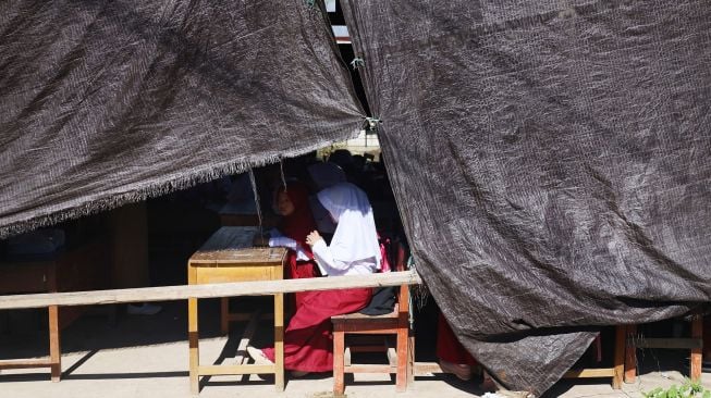 Siswa belajar di tenda darurat SD Inpres Binanga 2 Mamuju, Sulawesi Barat, Senin (29/8/2022).  ANTARA FOTO/Akbar Tado