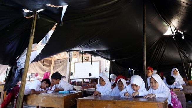 Siswa belajar di tenda darurat SD Inpres Binanga 2 Mamuju, Sulawesi Barat, Senin (29/8/2022).  ANTARA FOTO/Akbar Tado