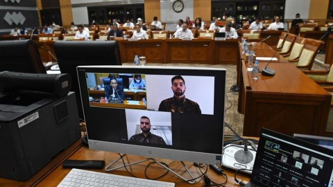 Pesepakbola Jordi Amat (layar bagian bawah) dan Sandy Walsh (layar sebelah kiri) mengikuti rapat kerja antara Komisi III DPR dengan Kementerian Pemuda dan Olahraga, Kementerian Hukum dan HAM, serta Persatuan Sepakbola Seluruh Indonesia (PSSI) di kompleks Parlemen, Senayan, Jakarta, Senin (29/8/2022). [ANTARA FOTO/Aditya Pradana Putra]