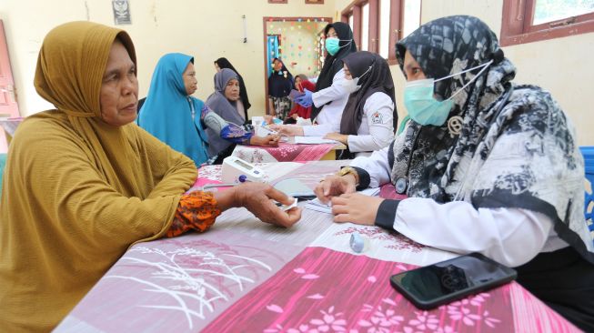 Petugas kesehatan memeriksa kesehatan dari seorang warga lanjut usia (lansia) di Posyandu Ayeum Mata, Desa Alue Raya, Samatiga, Aceh Barat, Aceh, Rabu (31/8/2022). [ANTARA FOTO/Syifa Yulinnas/wsj]